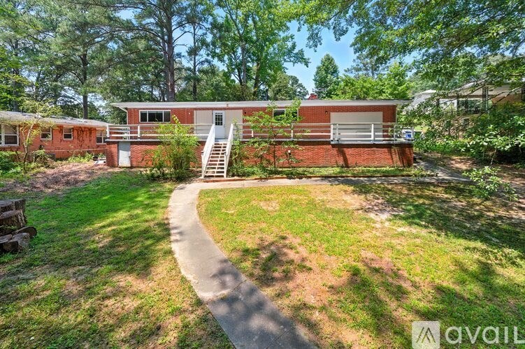 A red house with a white door and a staircase leading to the entrance.