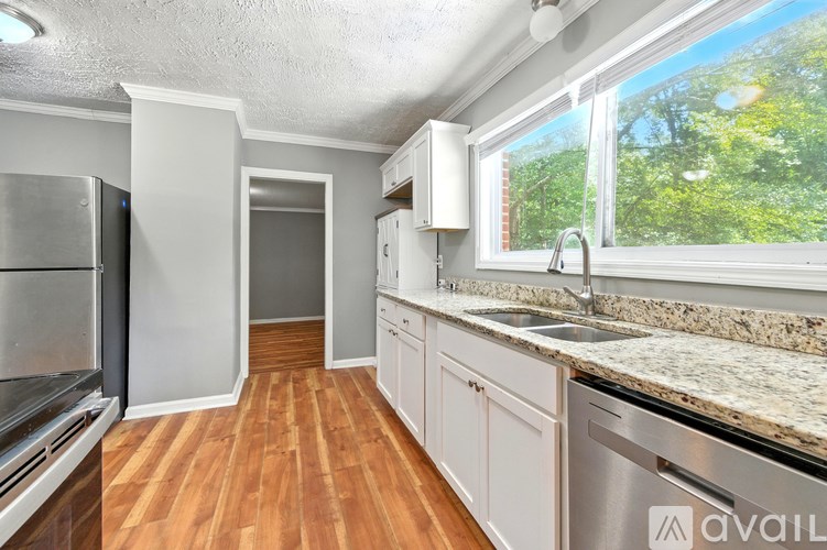 A kitchen with wooden floors and stainless steel appliances.