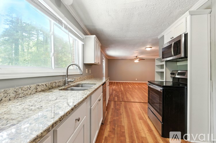 A kitchen with granite countertops and wooden floors.