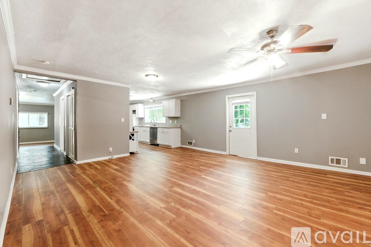 A room with wooden floors and a ceiling fan.