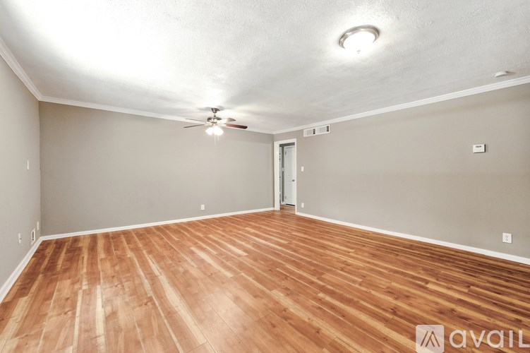 A room with wooden flooring and a ceiling fan.