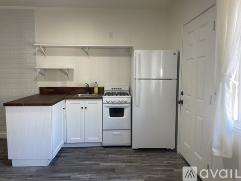 A kitchen with white appliances and cabinets.