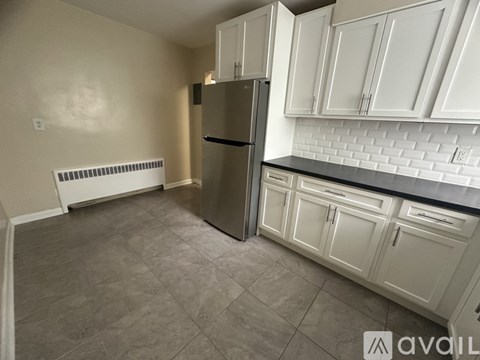 A kitchen with white cabinets and a black countertop.