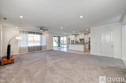A spacious living room with a television and a carpeted floor.