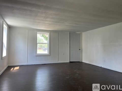 A room with a window and a door is available for rent.
