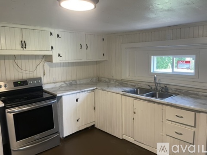 A kitchen with white cabinets and a black stove top oven.