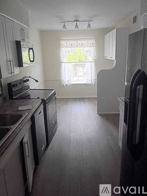 A kitchen with a refrigerator, sink, and stove.