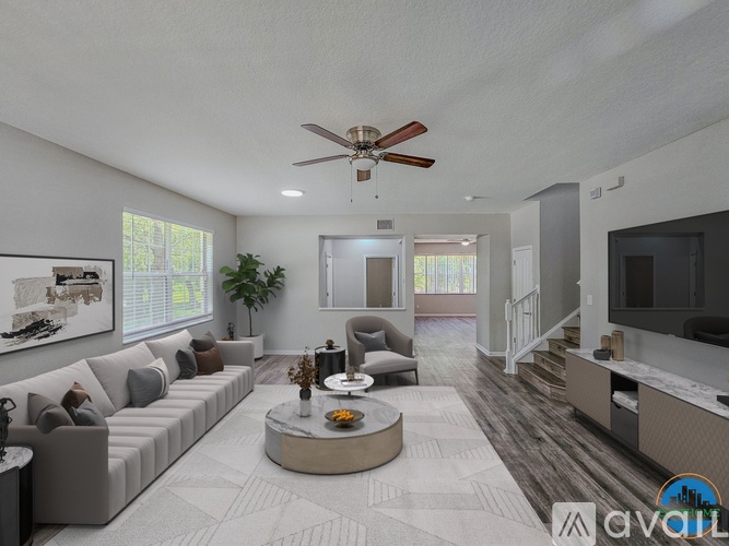 A living room with a grey sofa, a coffee table, and a ceiling fan.