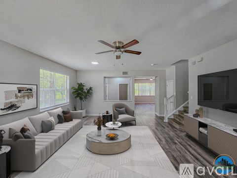 A living room with a grey sofa, a coffee table, and a ceiling fan.