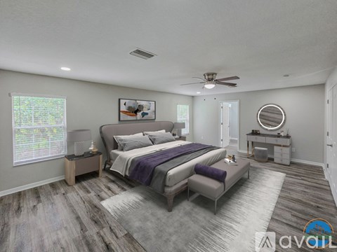 A bedroom with a large bed and a ceiling fan.