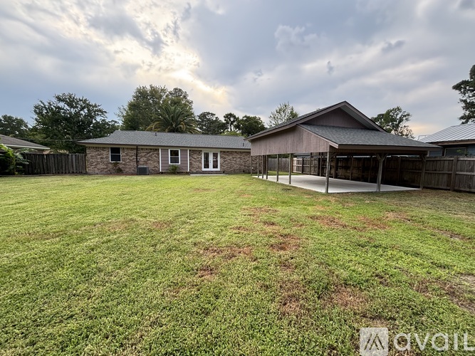 A large grassy yard with a house and a fence.
