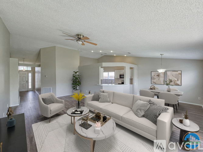 A spacious living room with a white sofa set and a coffee table.