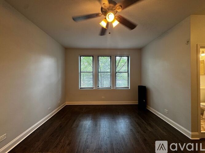 A room with a ceiling fan and a window with blinds.