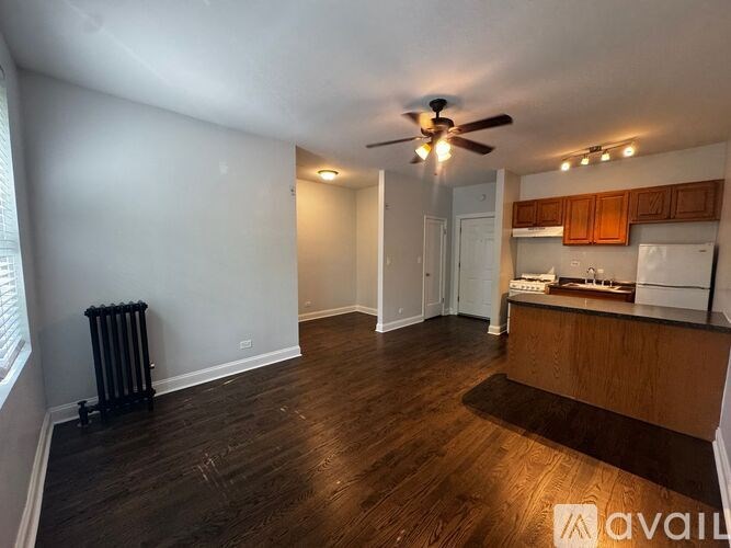 A living room with a wood floor and a ceiling fan.