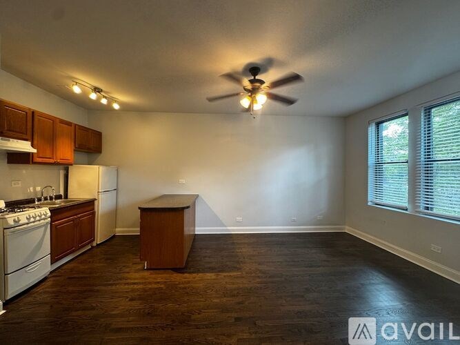 A kitchen with a white stove top oven and a white refrigerator with wooden cabinets.