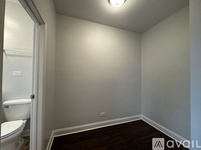 A small, empty room with a toilet visible through the door.