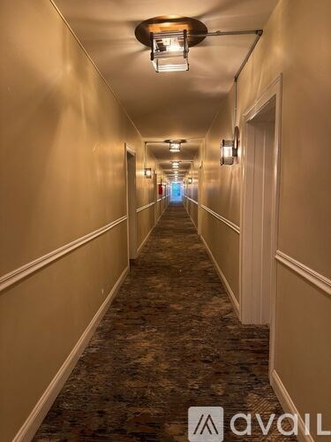A long hallway with a carpeted floor and white walls.