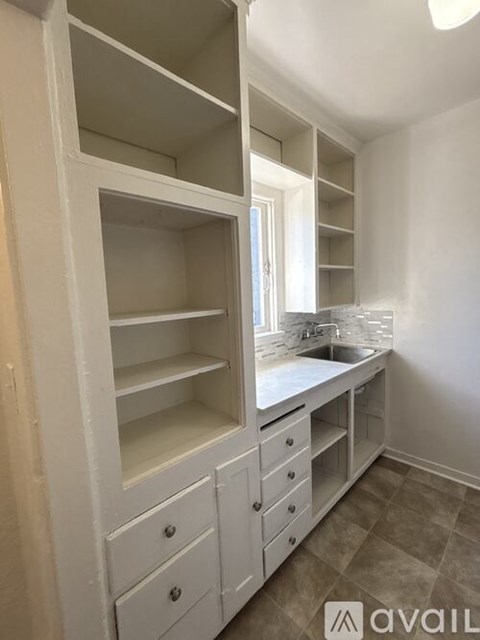 A kitchen with white cabinets and a sink.