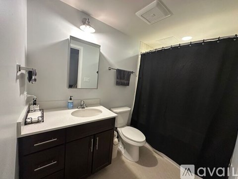 A white bathtub with a black shower curtain and a silver faucet.