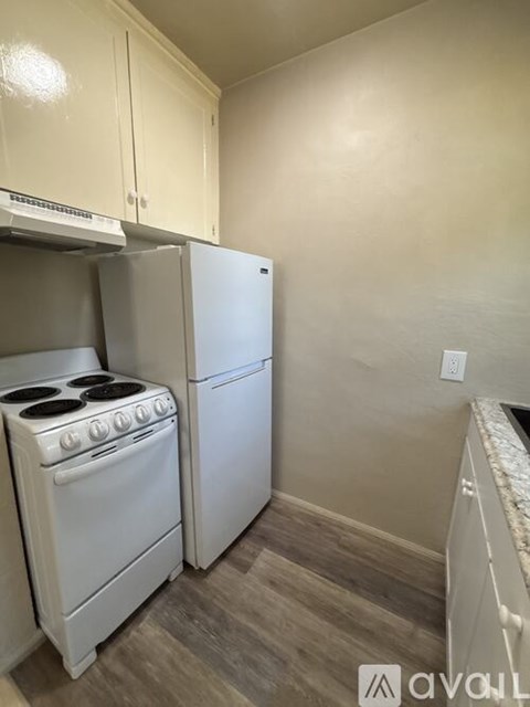 A kitchen with a white stove and refrigerator.