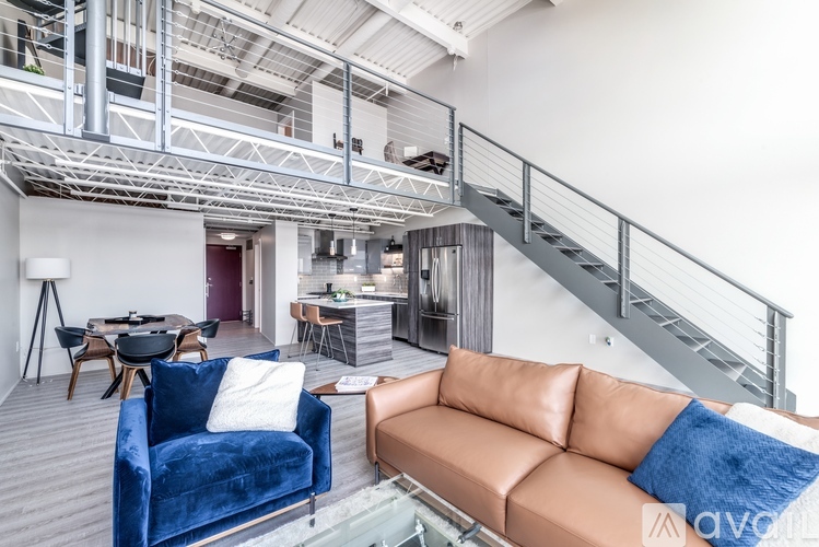 A living room with a blue velvet couch and a brown leather couch.