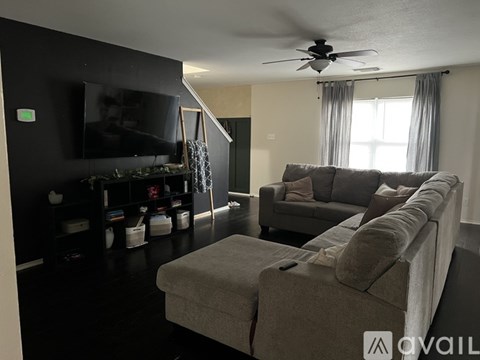 A living room with a grey couch and a television.