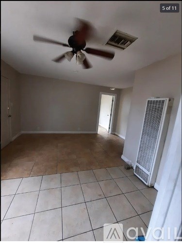 A room with a ceiling fan and tiled floor.