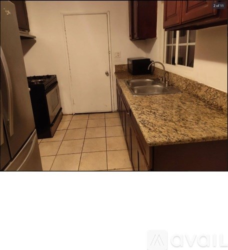 A kitchen with a sink and a white door.