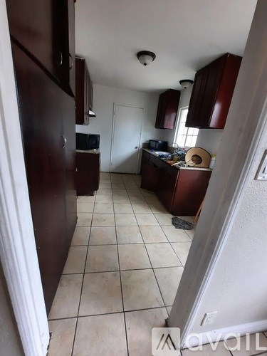 A kitchen with brown cabinets and a white refrigerator.