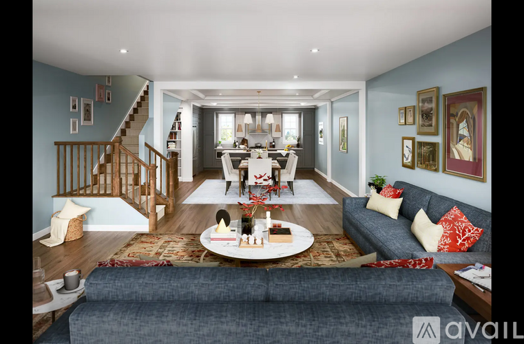 A living room with a grey couch and a wooden staircase.