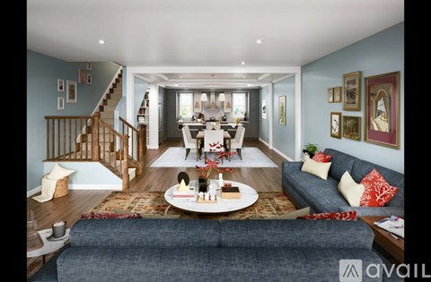 A living room with a grey couch and a wooden staircase.