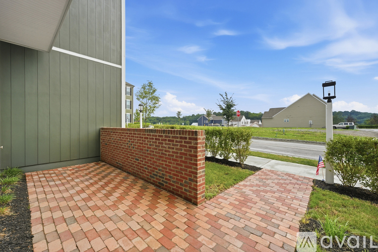 A brick wall with a pathway leading to a building.