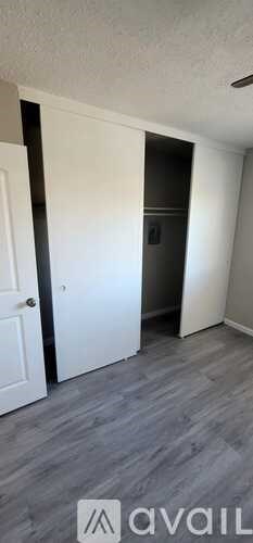 A room with a white door and a grey floor.