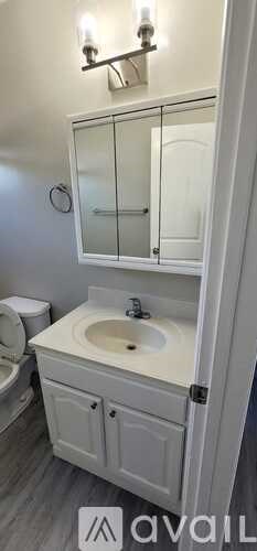 A white bathroom with a sink and mirror.
