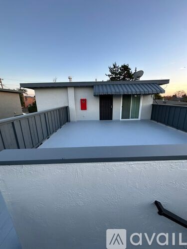 A small house with a red door and a satellite dish on the roof.