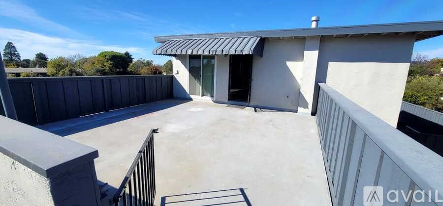A balcony with a metal railing and a concrete floor.