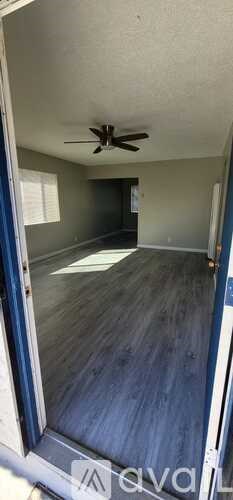 A room with a ceiling fan and a door.