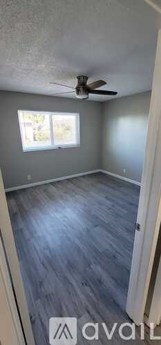 A room with a ceiling fan and a window.
