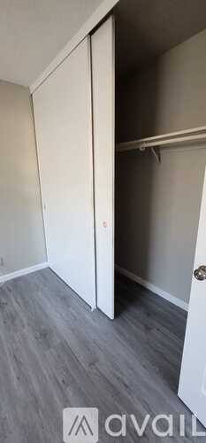 A room with a white door and a grey floor.