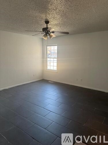 A room with a ceiling fan and a window.