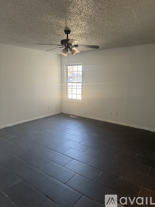 A room with a ceiling fan and a window.