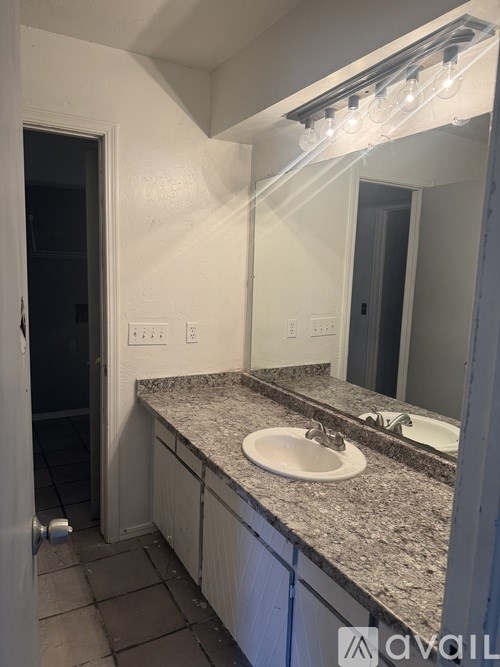 A bathroom with a granite countertop and a white sink.