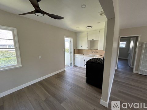 A room with a ceiling fan and wooden flooring.