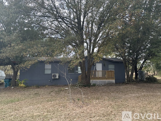 A grey building with a tree in front of it.