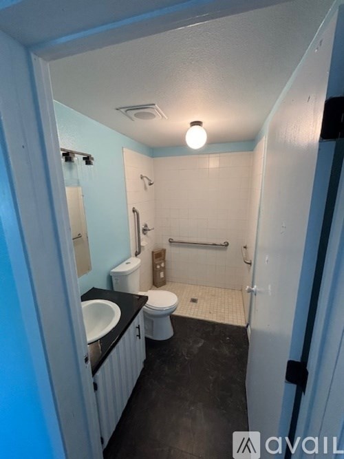 A bathroom with a toilet, sink, and shower.