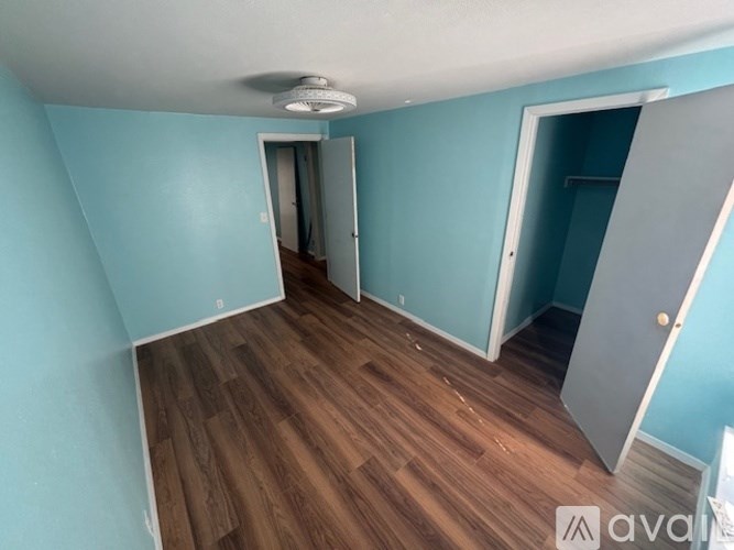 A room with wooden flooring and a ceiling fan.
