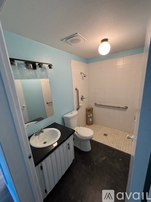 A bathroom with a toilet, sink, and shower.