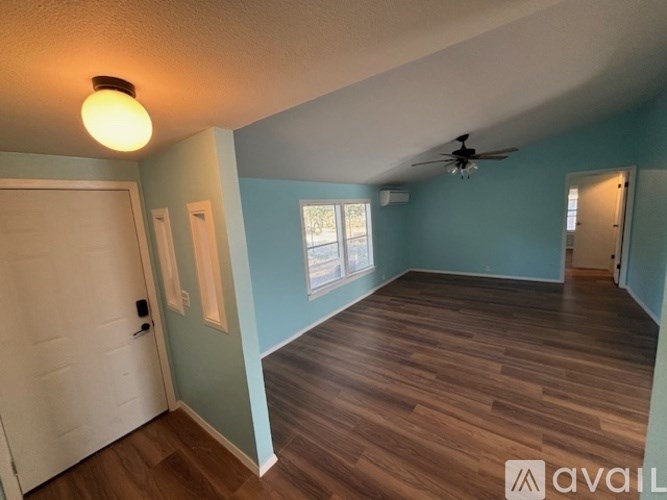 A room with wooden floors and a ceiling fan.