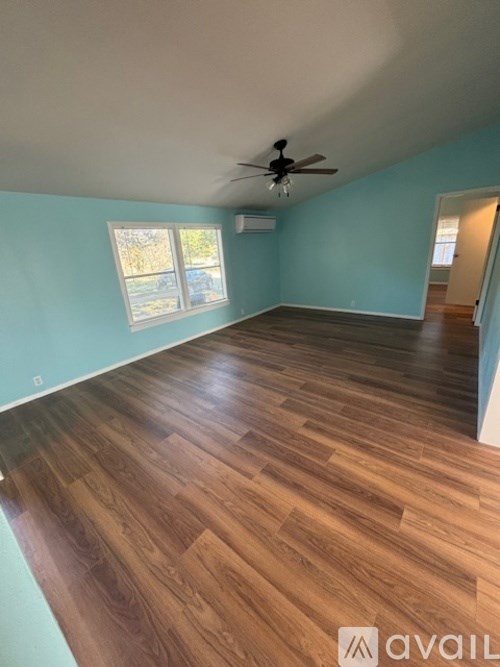 A room with wooden flooring and a ceiling fan.