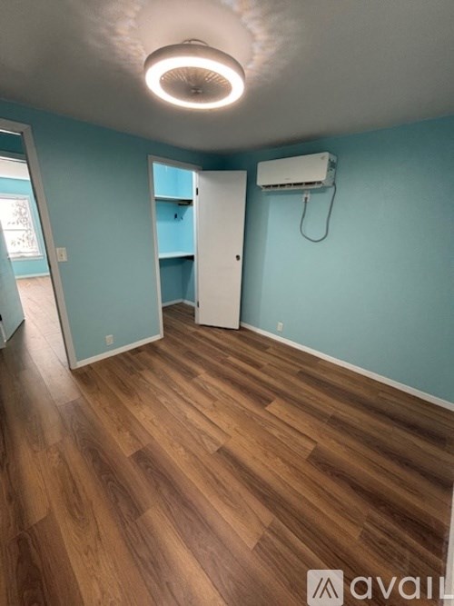 A room with wooden flooring and a white door.